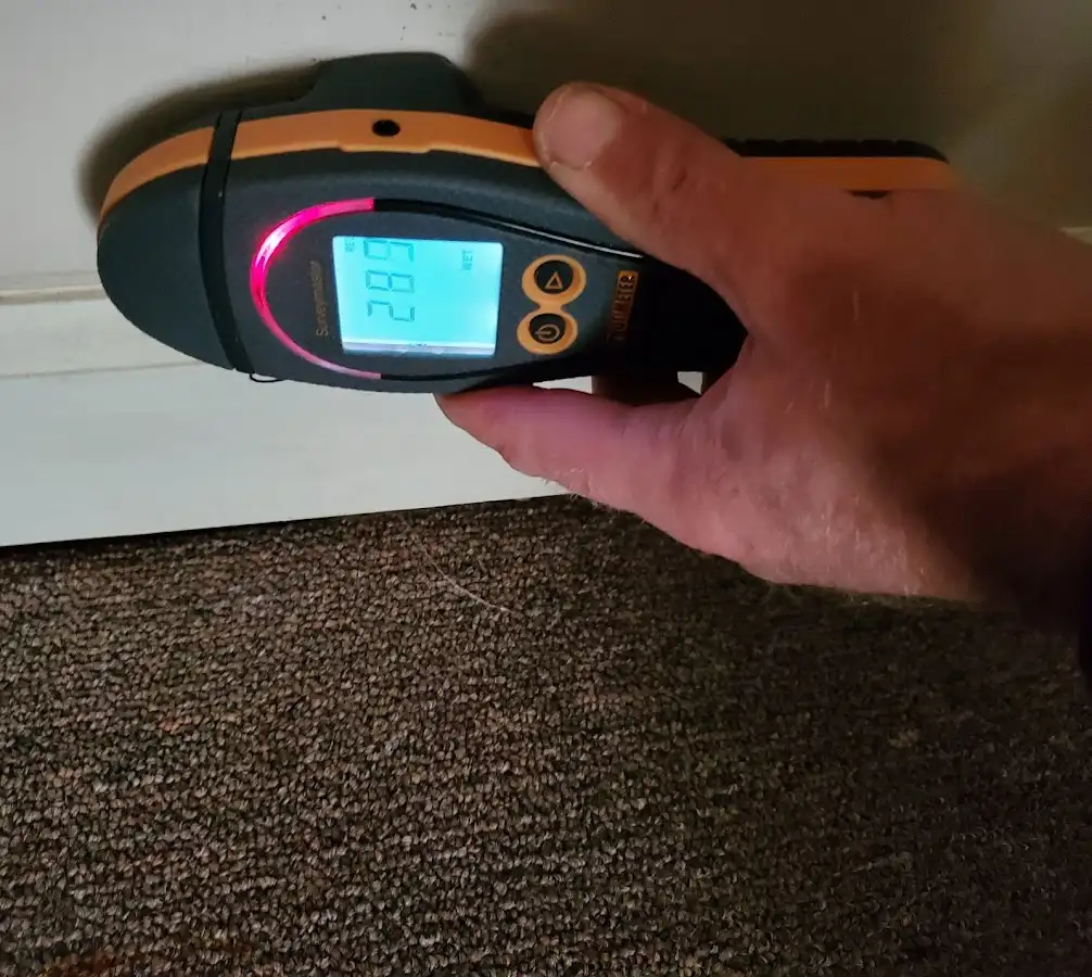 Moisture detection at baseboard during Storm Damage Restoration in LaBelle